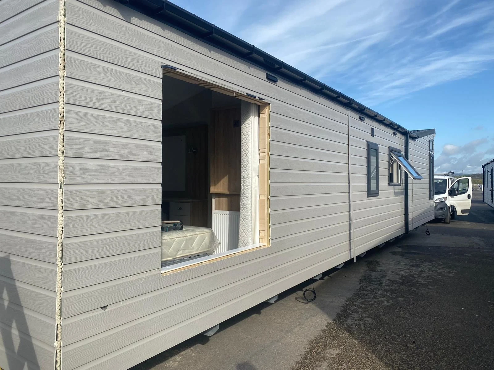 Static caravan exterior with the window opening exposed during repair